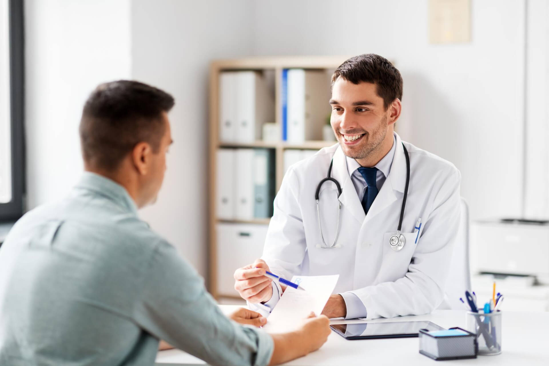 Doctor showing prescription to patient at hospital Doctor showing prescription to patient at hospital