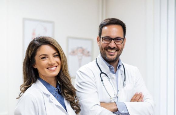 team Smiling male and female doctors standing together in a modern medical examination room